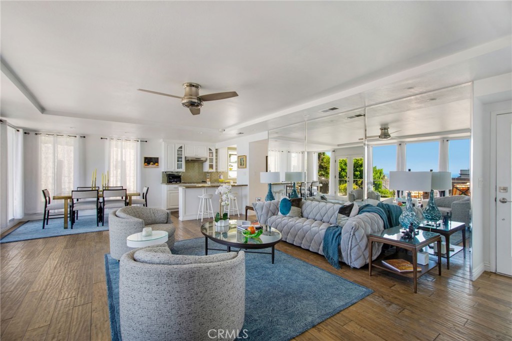Open concept living and dining room space, ceiling fan w/light expansive windows showcasing ocean view and direct patio - 31731 Seacove, Laguna Beach CA 92651 - photo 20