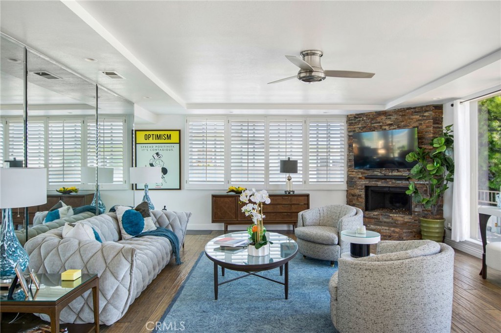 View from dining area towards living room with large wall mirrors, plantation shutters, stacked-stoned fireplace, recess - 31731 Seacove, Laguna Beach CA 92651 - photo 22