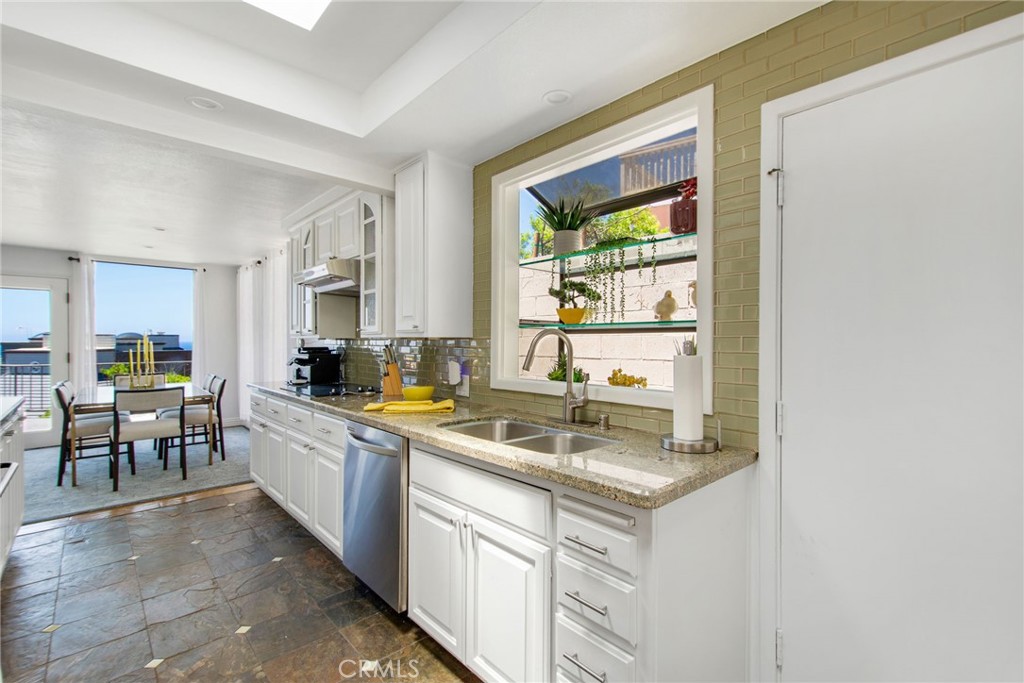 View of updated kitchen featuring a charming garden window with glass display shelves. - 31731 Seacove, Laguna Beach CA 92651 - photo 38