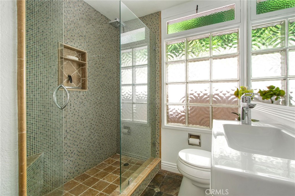 Guest bathroom walk in shower including mosaic tile walls, water fall shower head, tile floors and glass shower doors. - 31731 Seacove, Laguna Beach CA 92651 - photo 49