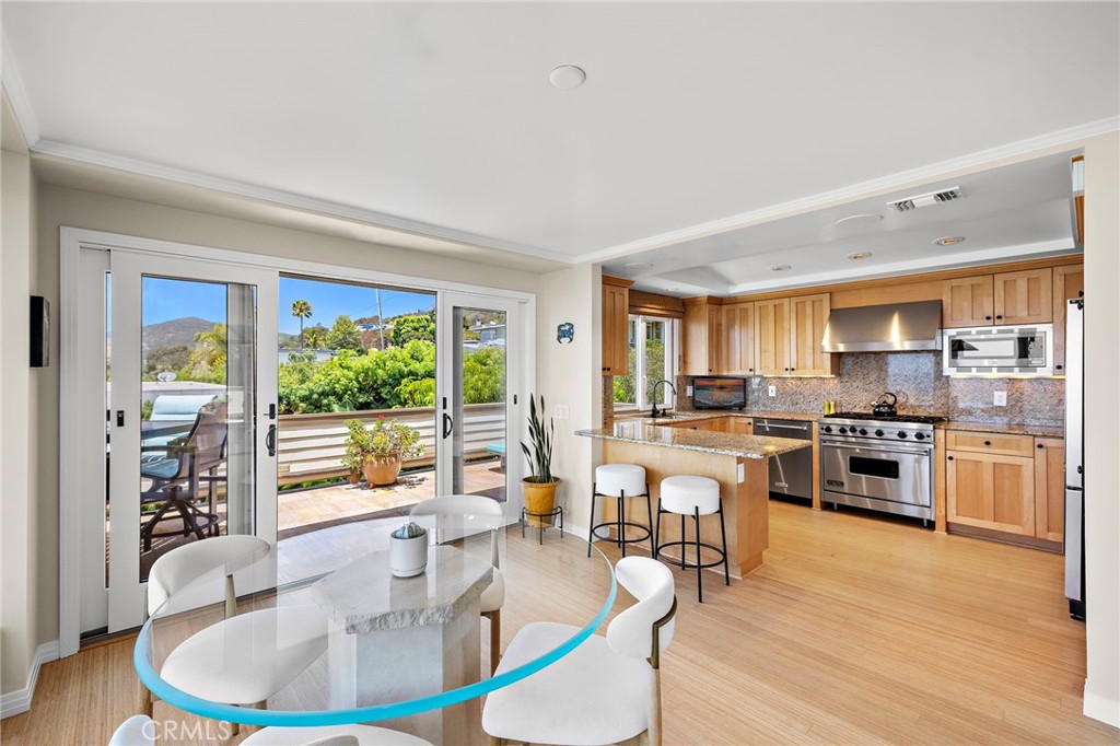 The kitchen features maple cabinetry, granite countertops, stainless steel appliances including a Viking oven with six-b - 31953 10th Avenue, Laguna Beach CA 92651 - photo 12