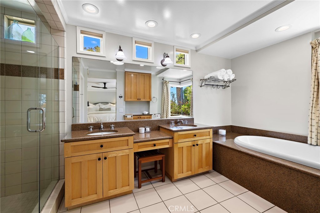 Spacious primary bath with a walk-in shower and jetted tub, complete with an ocean-view window above. - 31953 10th Avenue, Laguna Beach CA 92651 - photo 27
