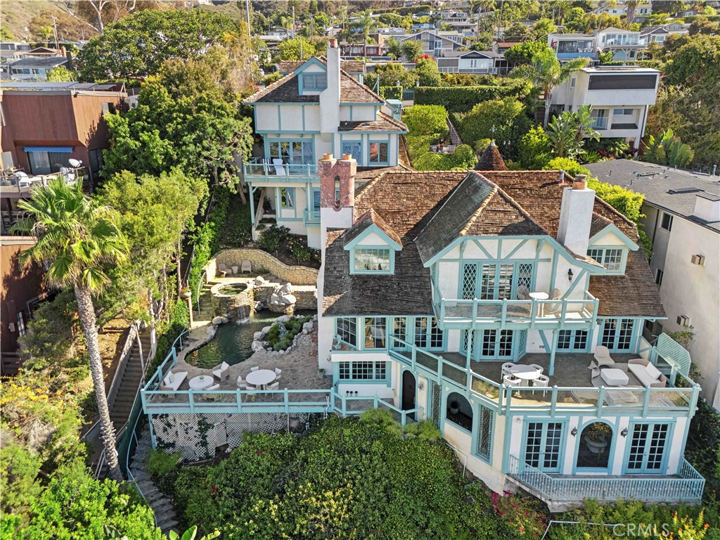 The main residence feels both grand and enchanting, with a stone turret, diamond-patterned windows, and a shingled roof - 31971 Coast Highway, Laguna Beach CA 92651 - photo 6