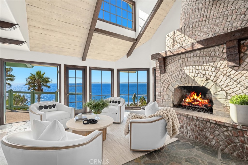 Inside, stone floors, a sculptural floating staircase, and soaring beamed ceilings frame endless ocean vistas. - 31971 Coast Highway, Laguna Beach CA 92651 - photo 7