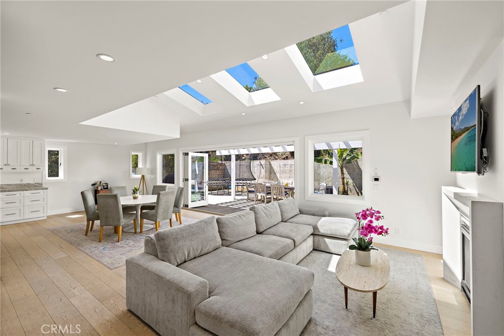 The open-concept layout transitions from the living room to the dining area and into a chef’s kitchen. - 3203 Tyrol Drive, Laguna Beach CA 92651 - photo 7