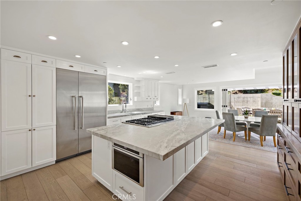 Chef’s kitchen complete with quartz countertops, an expansive island with breakfast bar seating, a high-end appliance pa - 3203 Tyrol Drive, Laguna Beach CA 92651 - photo 12
