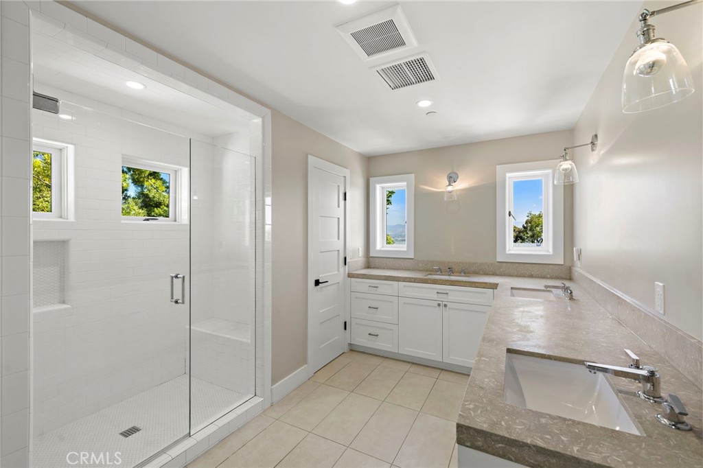 well-appointed hall bathroom featuring three sinks and a spacious walk-in shower. - 3203 Tyrol Drive, Laguna Beach CA 92651 - photo 31