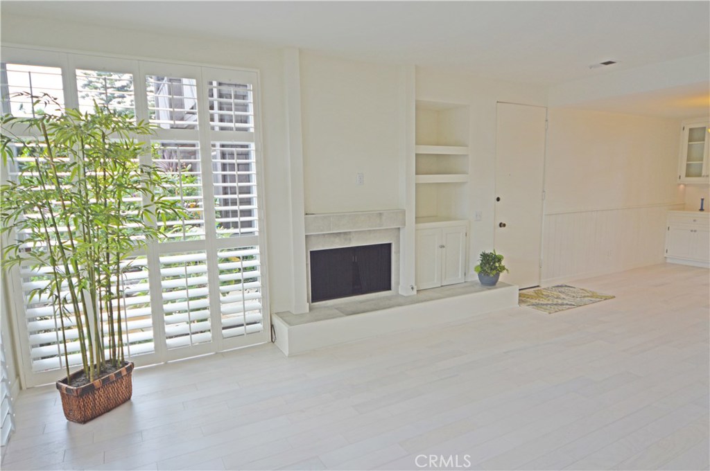Living room with very high ceilings and floor-to-ceiling windows. Quality custom wood shutters. Gas fireplace. - 339 Cypress Drive, Laguna Beach CA 92651 - photo 1