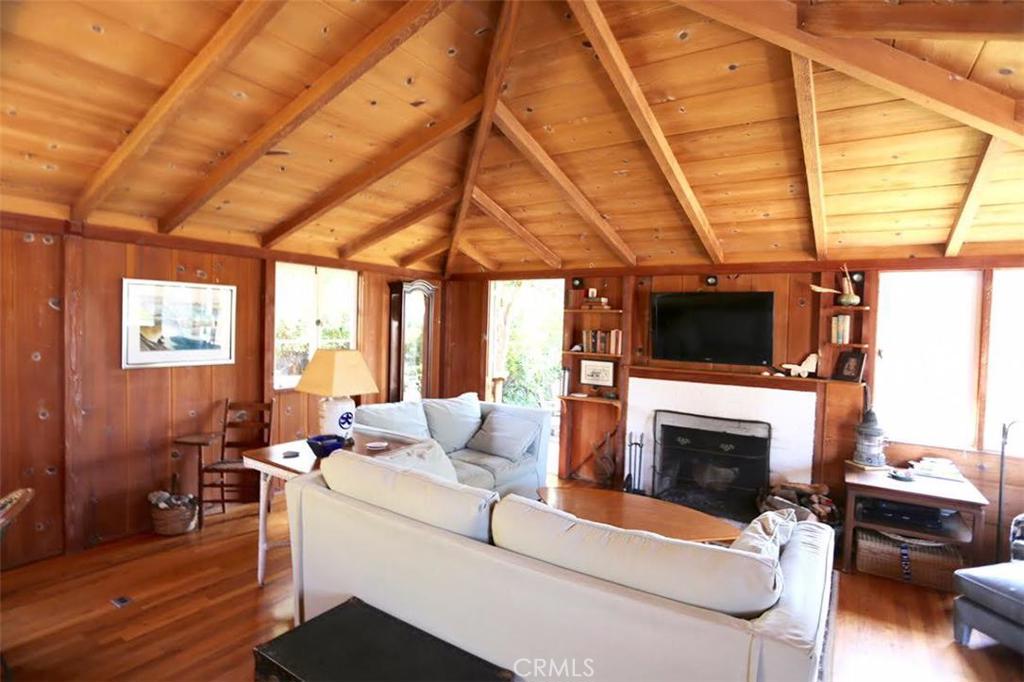 Beautiful wood paneled walls and exposed beam ceiling make the living room warm and inviting. - 546 Oak Street, Laguna Beach CA 92651 - photo 1