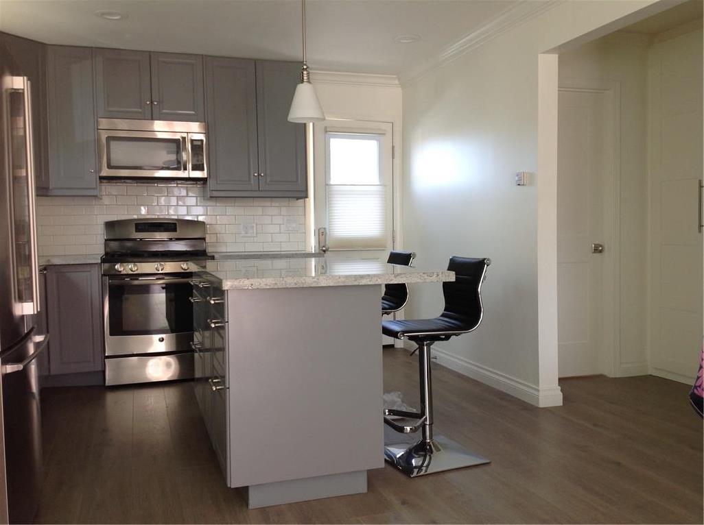 Kitchen with island. Wood laminated floors throughout - 552 Ramona Avenue, Laguna Beach CA 92651 - photo 1