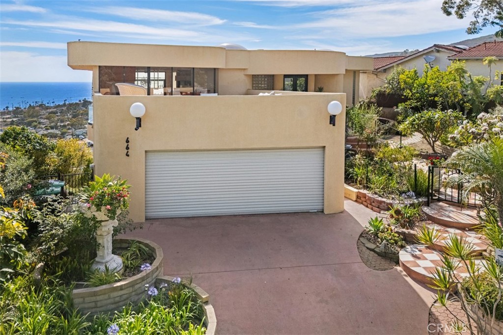 Two car attached garage with large open air deck above, resurfaced in recent years. Large commercial roll up garage door - 664 Mystic View, Laguna Beach CA 92651 - photo 11