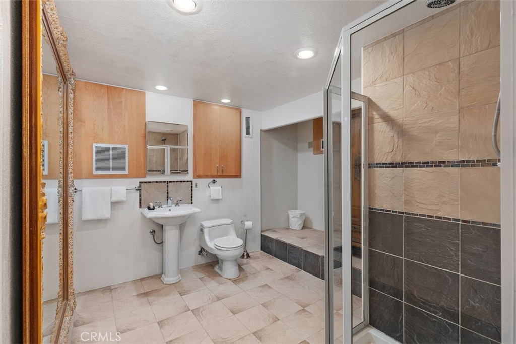 Guest quarters bathroom has storage armoire to right, shower stall and cabinets. - 664 Mystic View, Laguna Beach CA 92651 - photo 52