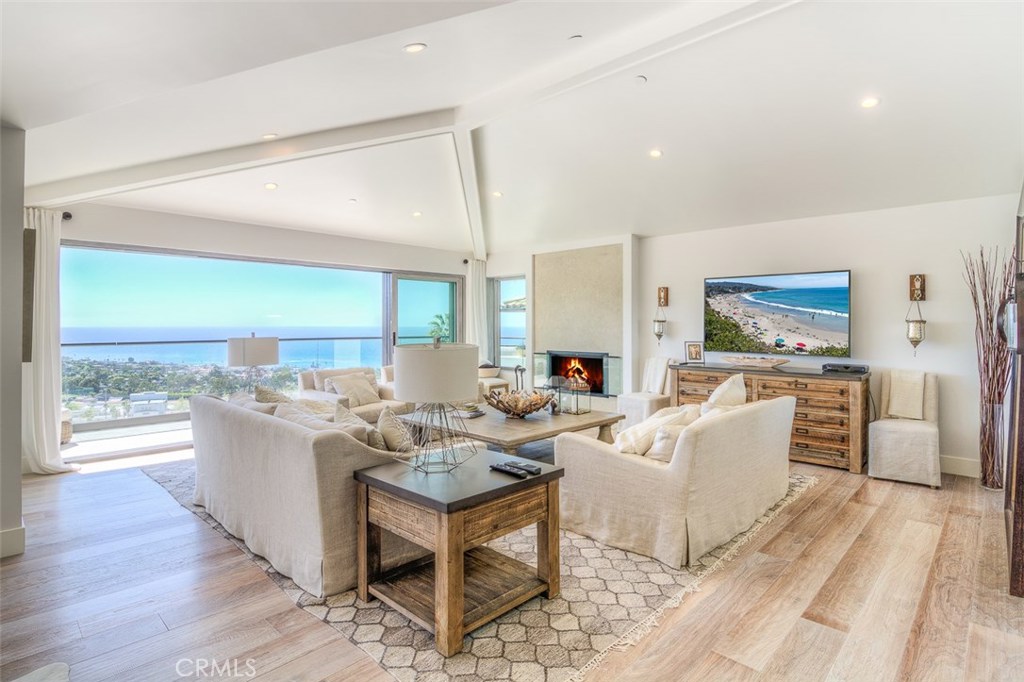 First of two living areas feature a disappearing glass slider that provides stunning panoramic ocean view with balcony. - 677 Mystic Way, Laguna Beach CA 92651 - photo 1