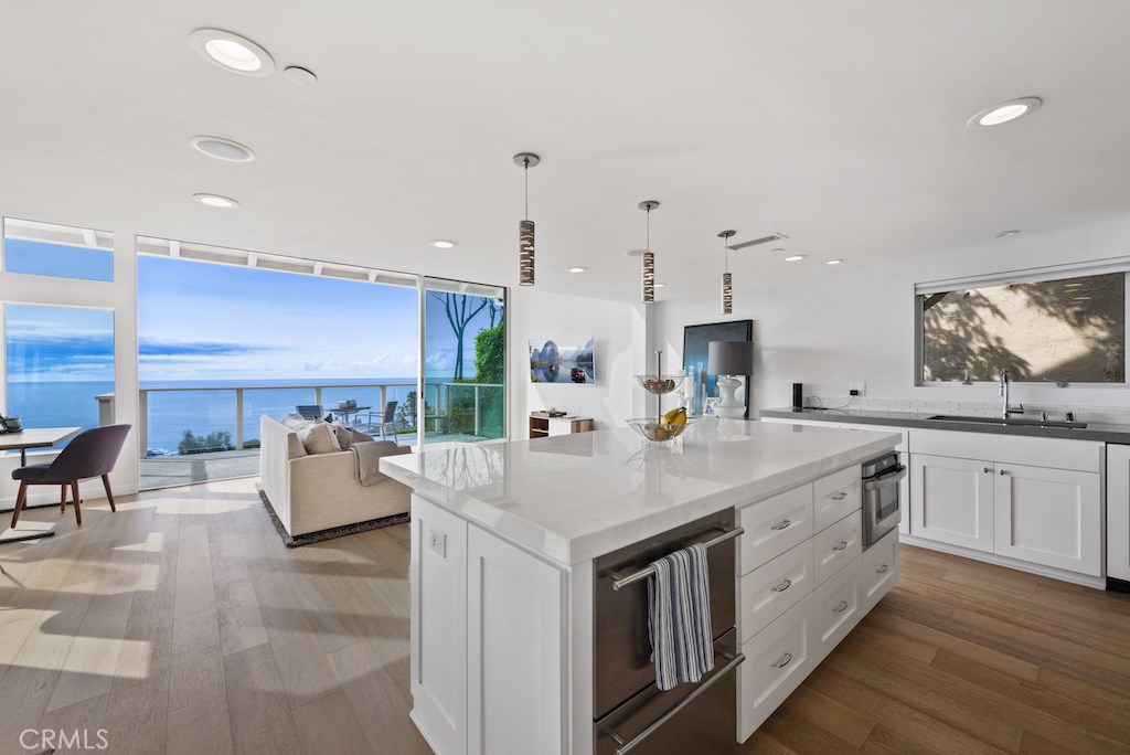 Kitchen looking towards the living room with a wall of glass showcasing the panoramic ocean, coastline, Catalina, and ci - 730 Fontana Way, Laguna Beach CA 92651 - photo 1