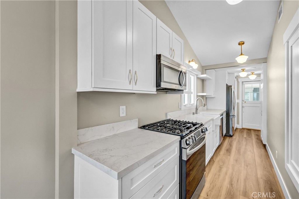 Kitchen | Beautiful quartz countertops, a farmhouse sink, stylish finishes, soft-close drawers, and plenty of cabinet sp - 826 S Coast A, Laguna Beach CA 92651 - photo 3