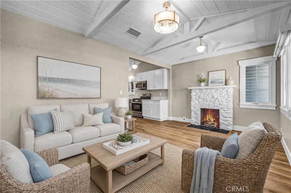 AI-Staged Living Room | Cozy fireplace, peek-a-boo ocean views, and inviting coastal charm. - 826 S Coast B, Laguna Beach CA 92651 - photo 3