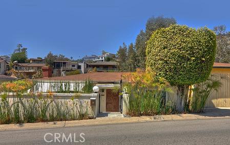 Exterior of home with bamboo landscaping, wooden gated entry. - 888 Bluebird Canyon Drive, Laguna Beach CA 92651 - photo 1
