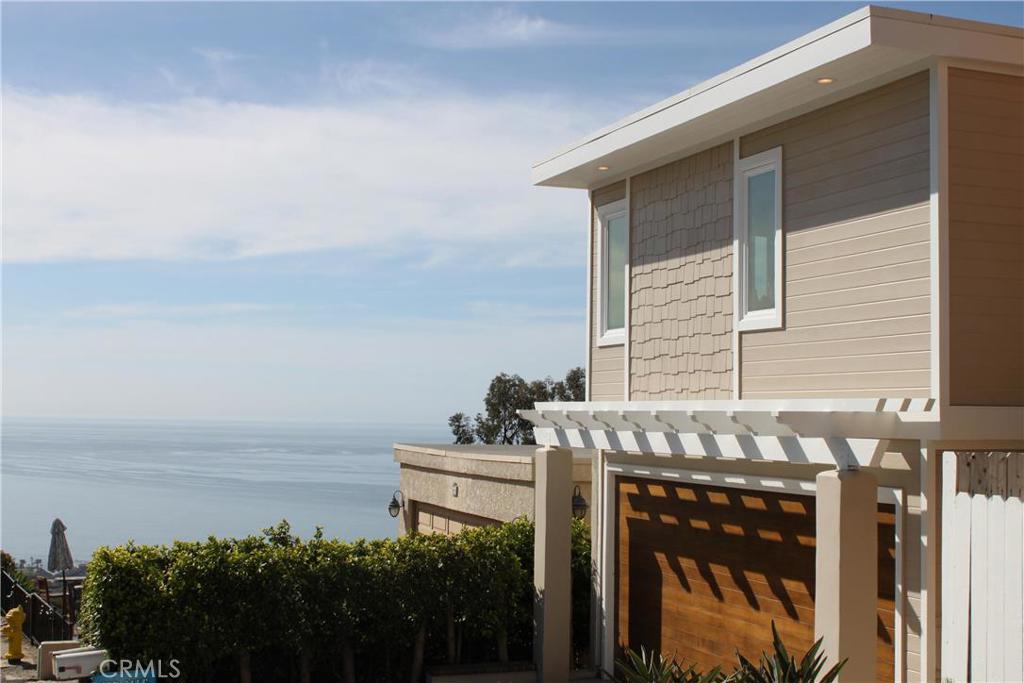 Custom wooden garage door with arbor. Two car garage with full car driveway. Custom design shingle accent will wood sidi - 971 Noria Street, Laguna Beach CA 92651 - photo 1
