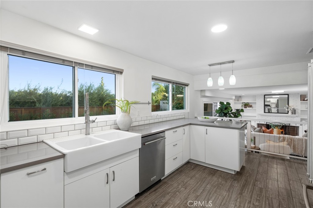 Kitchen features lovely cabinetry, stone countertops, stylish tile backsplash, breakfast bar, & a newer KitchenAid refri - 25182 Stockport, Laguna Hills CA 92653 - photo 13
