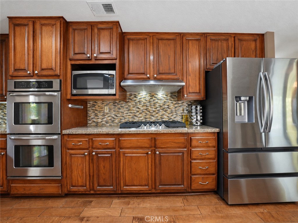 The kitchen features granite counters and stainless-steel appliances for a modern touch. - 25652 Nottingham Court, Laguna Hills CA 92653 - photo 9