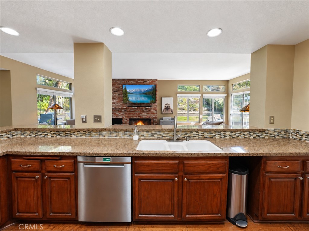 This modern functional kitchen with rich cabinets and counter seating is picturesque overlooking the yard. - 25652 Nottingham Court, Laguna Hills CA 92653 - photo 10