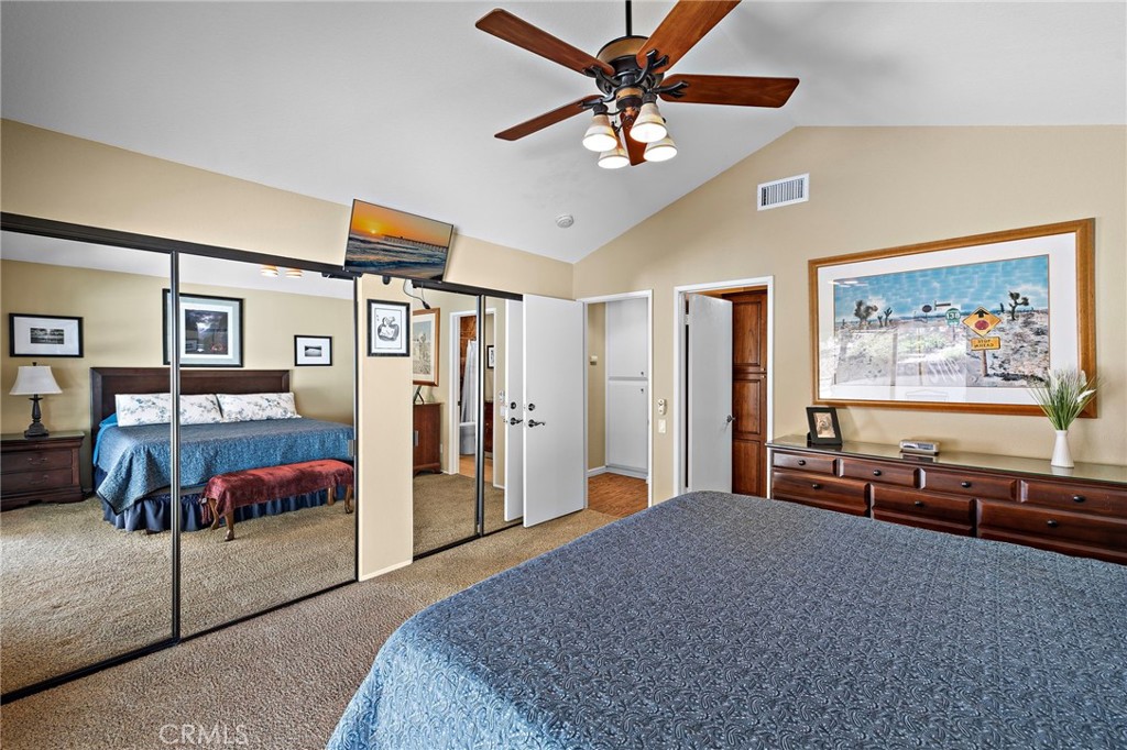 Primary bedroom with dual mirrored closet doors and ceiling fan - 30 Oxbow Creek, Laguna Hills CA 92653 - photo 19