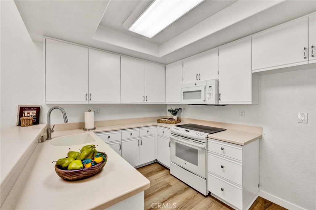 Freshly refreshed kitchen cabinets with upgraded hardware, a new kitchen sink, and durable Corian countertops. - 22 Aruba, Laguna Niguel CA 92677 - photo 4