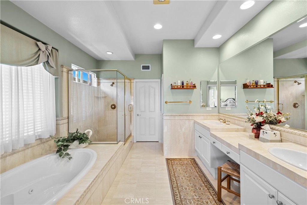 Primary Suite Opens to a Luxurious Primary Bathroom Accented in Elegant Stone for the Dual Vanity, Jetted Spa Tub, Showe - 23611 Trinidad Lane, Laguna Niguel CA 92677 - photo 24