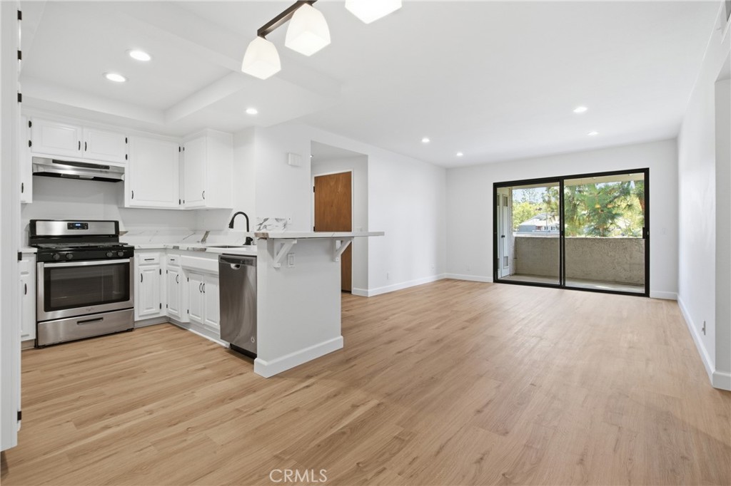 Light-filled living room featuring new luxury vinyl plank flooring, fresh interior paint, new baseboards and recessed li - 24278 El Pilar, Laguna Niguel CA 92677 - photo 2
