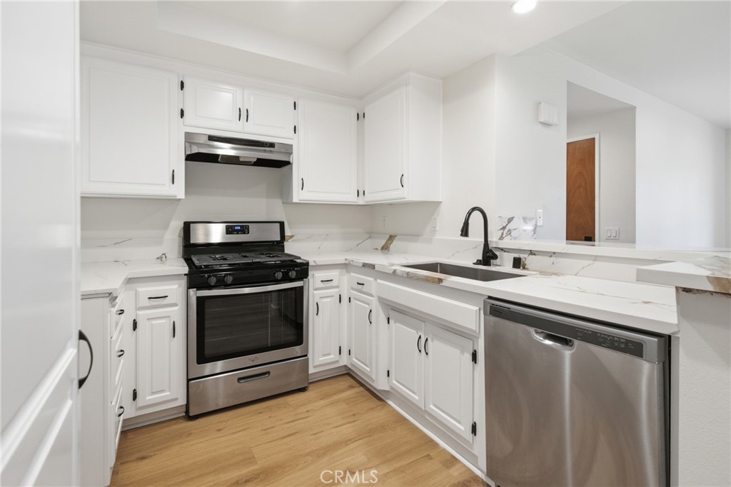 Updated kitchen featuring quartz countertops, refinished cabinetry, modern hardware and fixtures, and a stainless steel - 24278 El Pilar, Laguna Niguel CA 92677 - photo 3