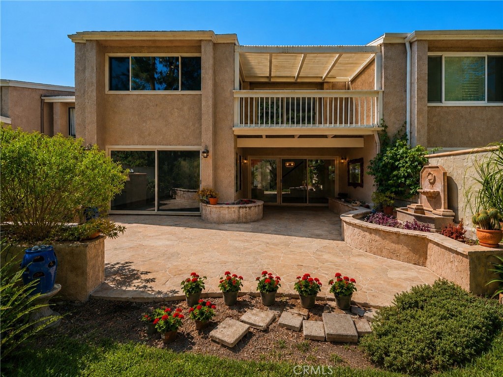 Inviting rear outdoor living area with expansive stone patio, raised fountain, mature landscaping, and private balcony - 24356 Hillview, Laguna Niguel CA 92677 - photo 29