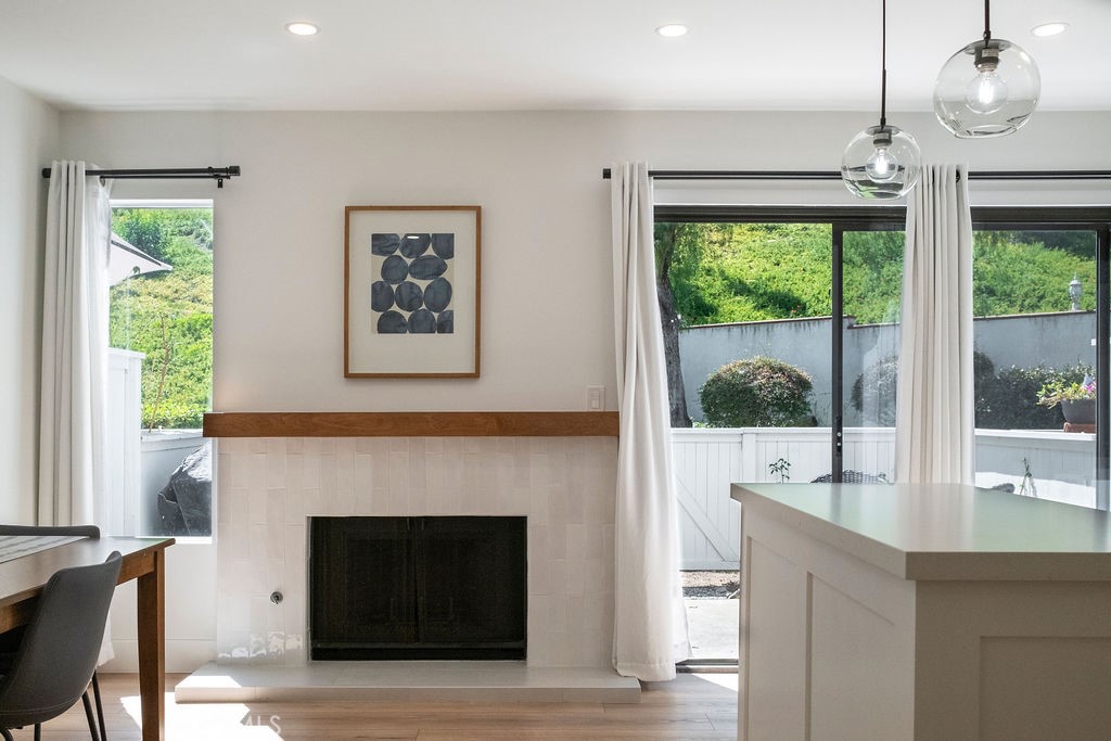 View of sunny family kitchen with updated fireplace and island - 25655 Paseo La Cresta 47, Laguna Niguel CA 92677 - photo 11