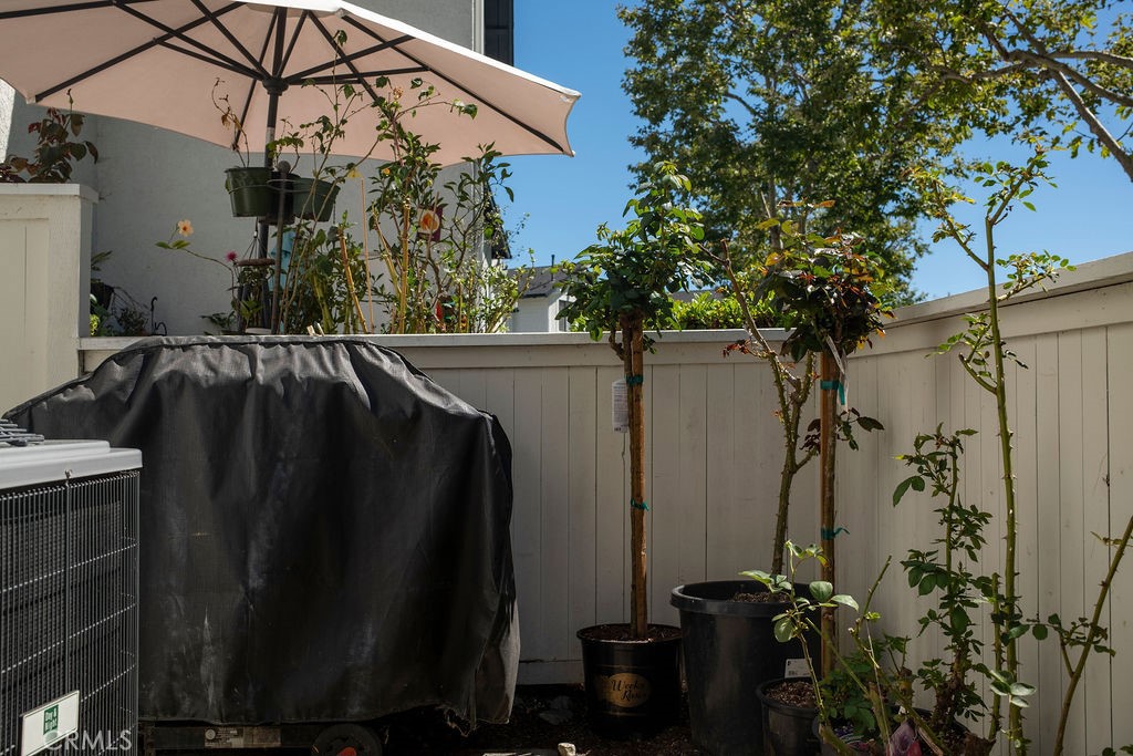 Sunny patio view showing updated AC condenser/compressor, included barbeque. Note: Potted plants belong to neighbor. - 25655 Paseo La Cresta 47, Laguna Niguel CA 92677 - photo 21