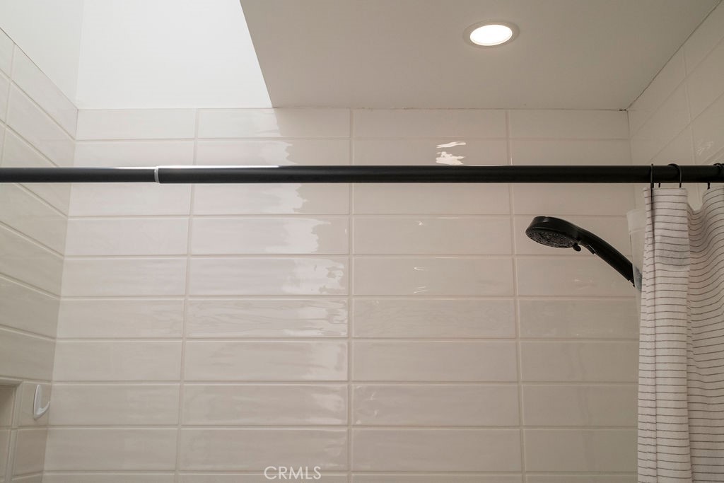 Close-up of updated tile surround, downlighting, and vaulted skylight in upstairs bathroom. - 25655 Paseo La Cresta 47, Laguna Niguel CA 92677 - photo 35