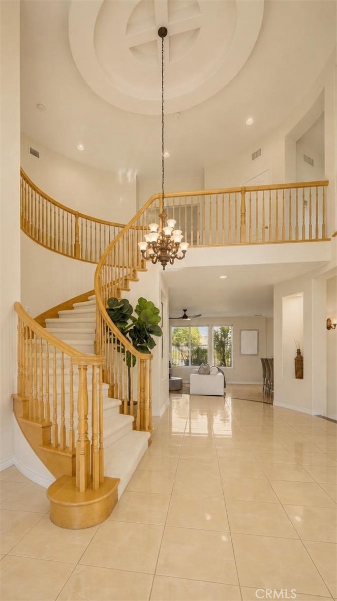 Sophisticated estate foyer with a sweeping curved staircase and soaring chandelier-lit ceilings. - 28932 Drakes Bay, Laguna Niguel CA 92677 - photo 6