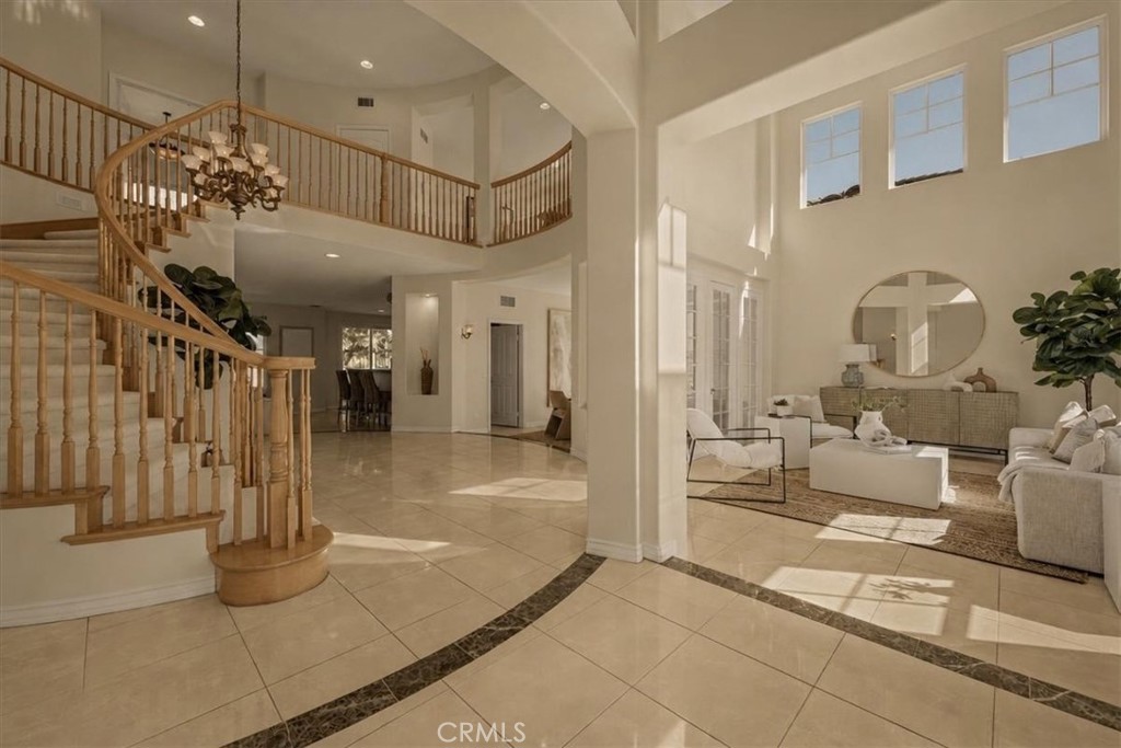 Luminous estate interior with a sweeping staircase, soaring ceilings, and gleaming tile floors. - 28932 Drakes Bay, Laguna Niguel CA 92677 - photo 7