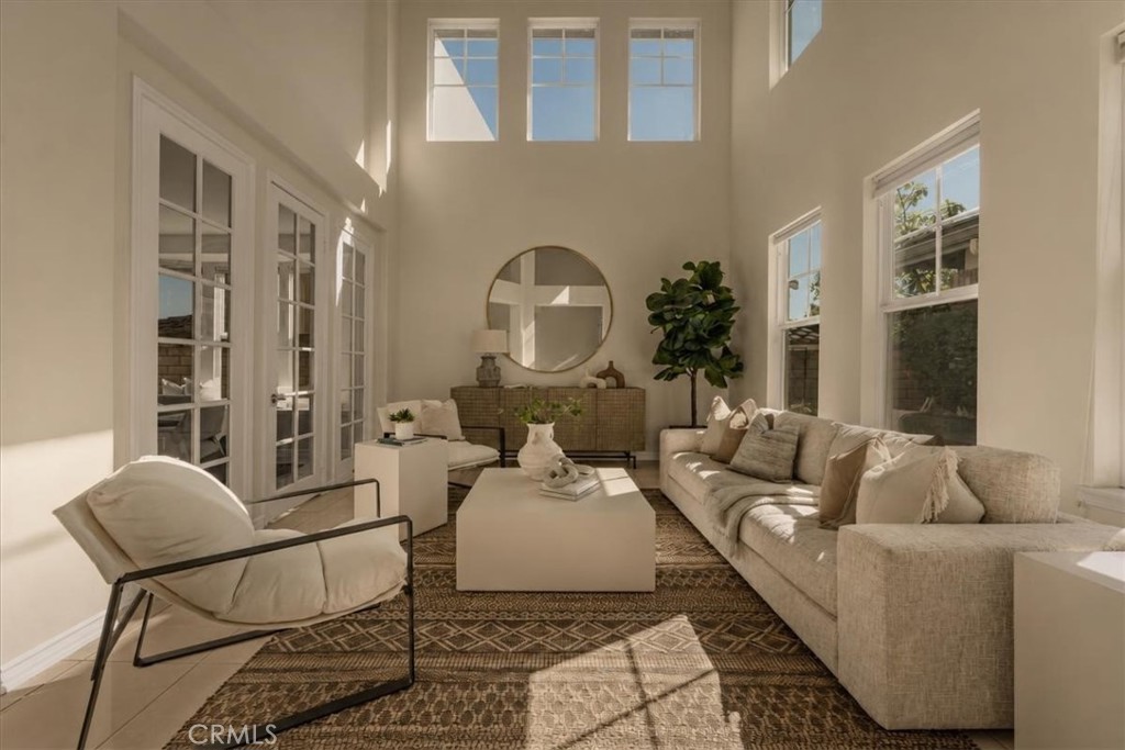 Sun-drenched living room with soaring ceilings and French doors. - 28932 Drakes Bay, Laguna Niguel CA 92677 - photo 8