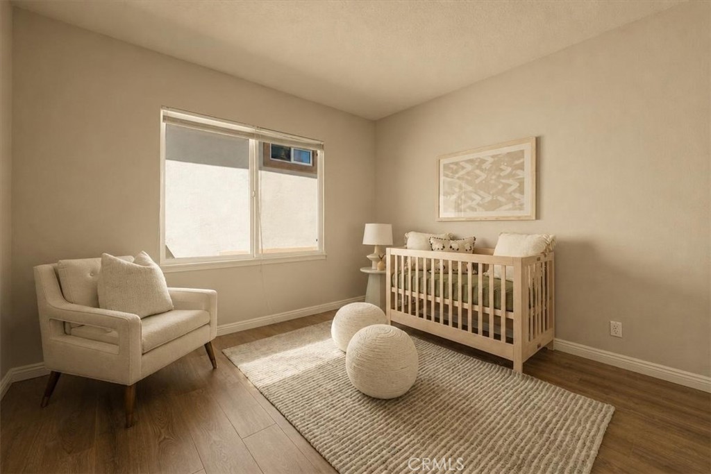 A serene fourth bedroom with warm wood flooring and soft neutral tones, ideal as a nursery, guest retreat, or private st - 28932 Drakes Bay, Laguna Niguel CA 92677 - photo 20