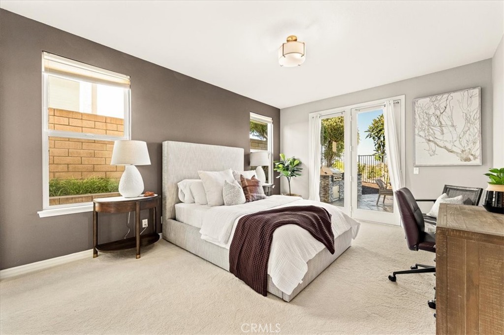 A serene primary suite with plush carpeting, and French doors opening to a private patio retreat. - 28932 Drakes Bay, Laguna Niguel CA 92677 - photo 34