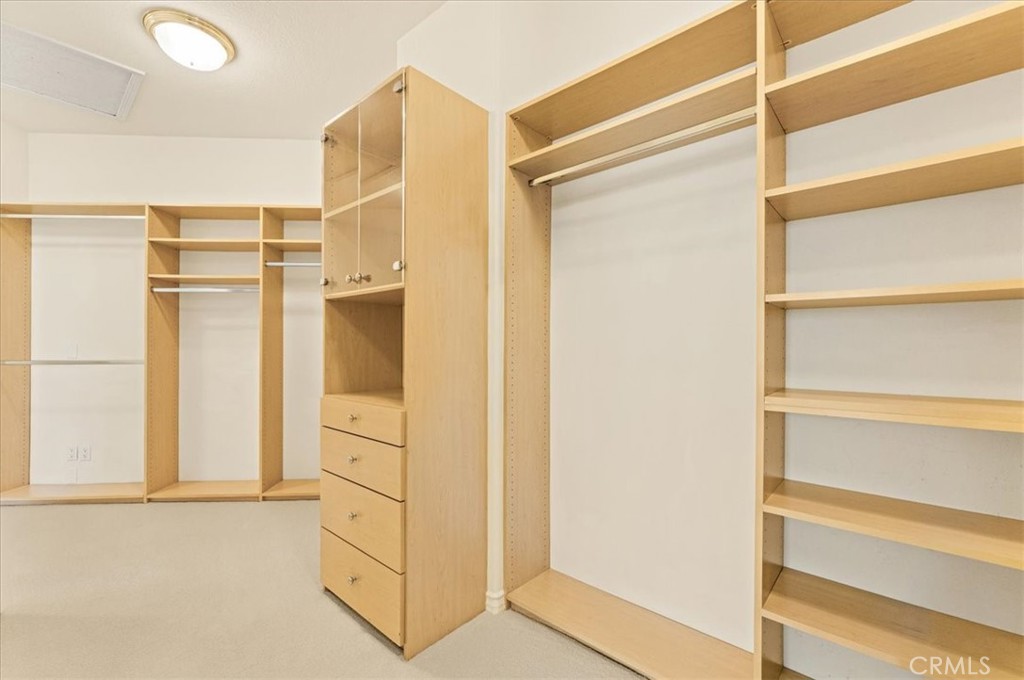 An expansive walk-in closet with custom built-in cabinetry, - 28932 Drakes Bay, Laguna Niguel CA 92677 - photo 57