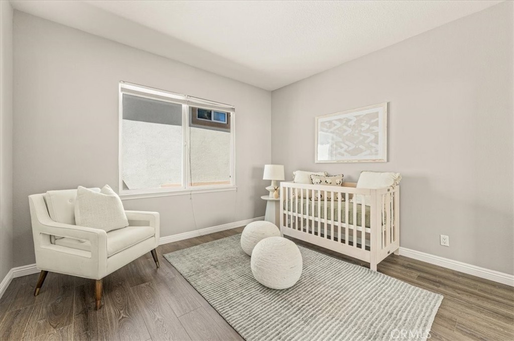A serene fourth bedroom with warm wood flooring and soft neutral tones, ideal as a nursery, guest retreat, or private st - 28932 Drakes Bay, Laguna Niguel CA 92677 - photo 60