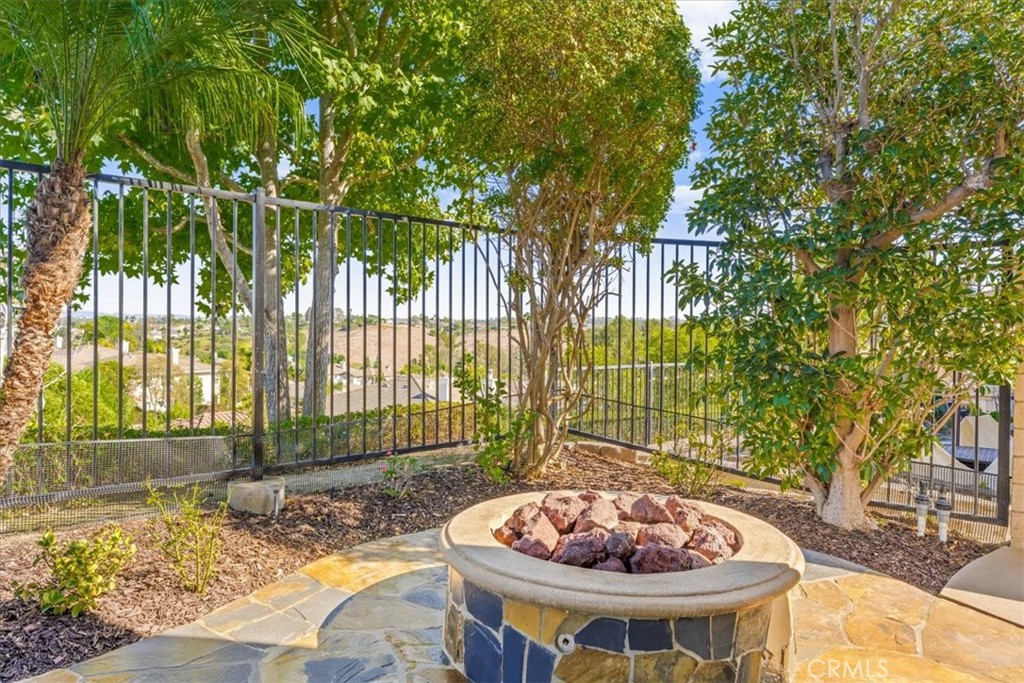 A stone fire pit nestled among lush greenery, offering a captivating gathering spot with sweeping hillside views. - 28932 Drakes Bay, Laguna Niguel CA 92677 - photo 68
