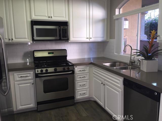Upgraded kitchen with new quartz countertop and ceramic tile that looks like wood - 30902 Clubhouse Drive 5B, Laguna Niguel CA 92677 - photo 1