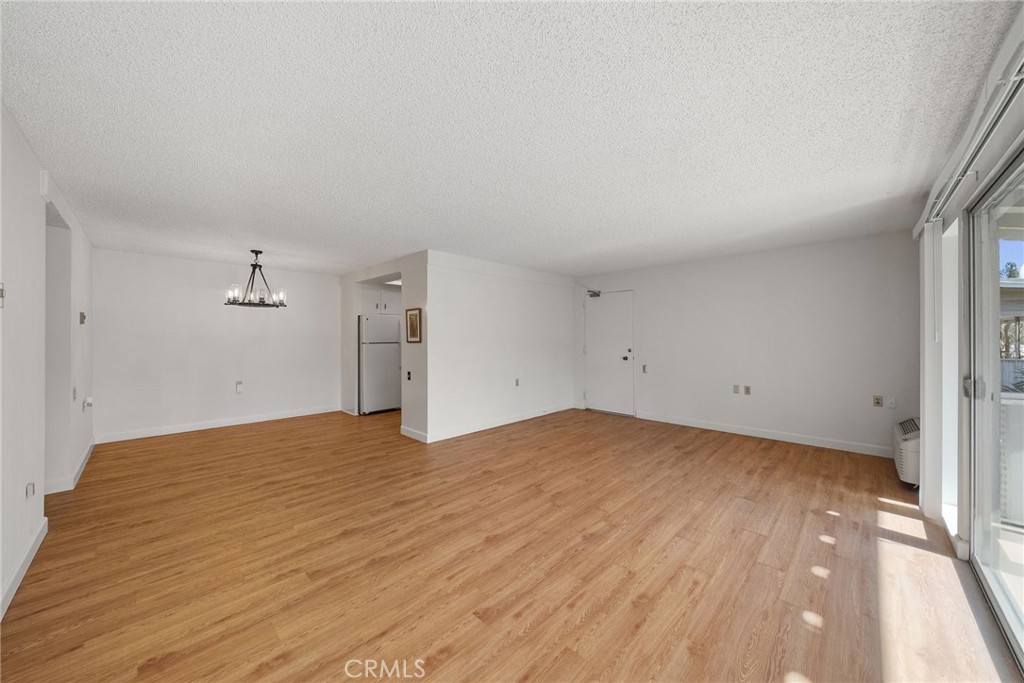 The living room opens to the dedicated dining room with an upgraded chandelier! - 225 Avenida Majorca N, Laguna Woods CA 92637 - photo 6