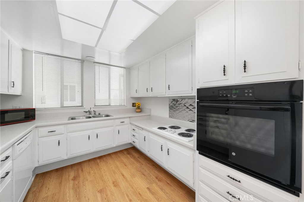 Appliances include a built in oven, electric stove top, dishwasher, counter top microwave, refrigerator and garbage disp - 225 Avenida Majorca N, Laguna Woods CA 92637 - photo 10