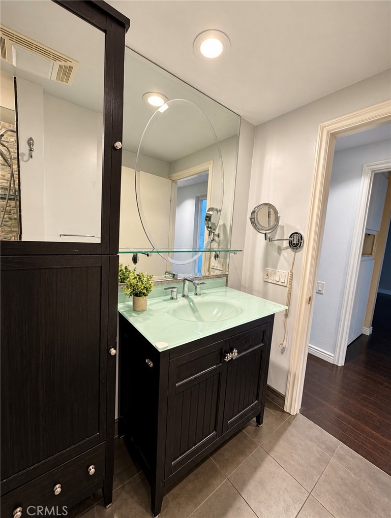 The luxuriously remodeled primary bath offers abundant storage and bright, flattering lighting. - 2346 Via Mariposa W A, Laguna Woods CA 92637 - photo 19