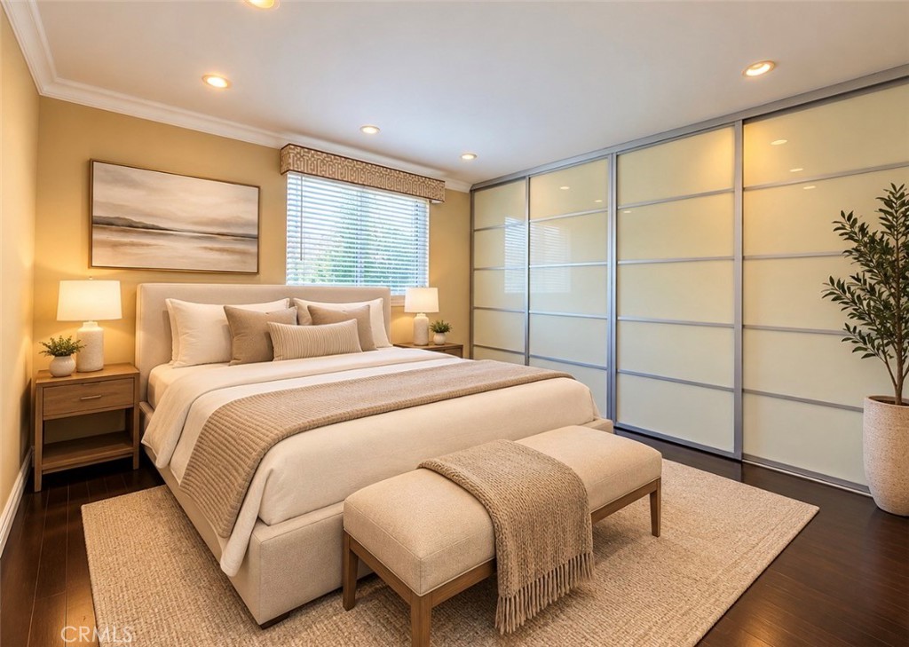 The bright second bedroom offers bamboo flooring and a wide closet with sleek glass doors, ideal for guests, a home offi - 2346 Via Mariposa W A, Laguna Woods CA 92637 - photo 16