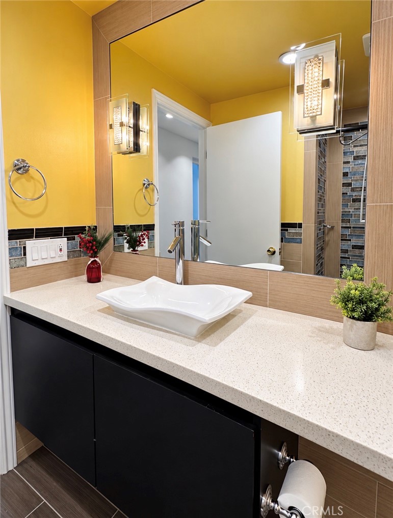Another view of the secondary bath, beautifully remodeled with quartz countertops and custom tile and modern sink. - 2346 Via Mariposa W A, Laguna Woods CA 92637 - photo 23