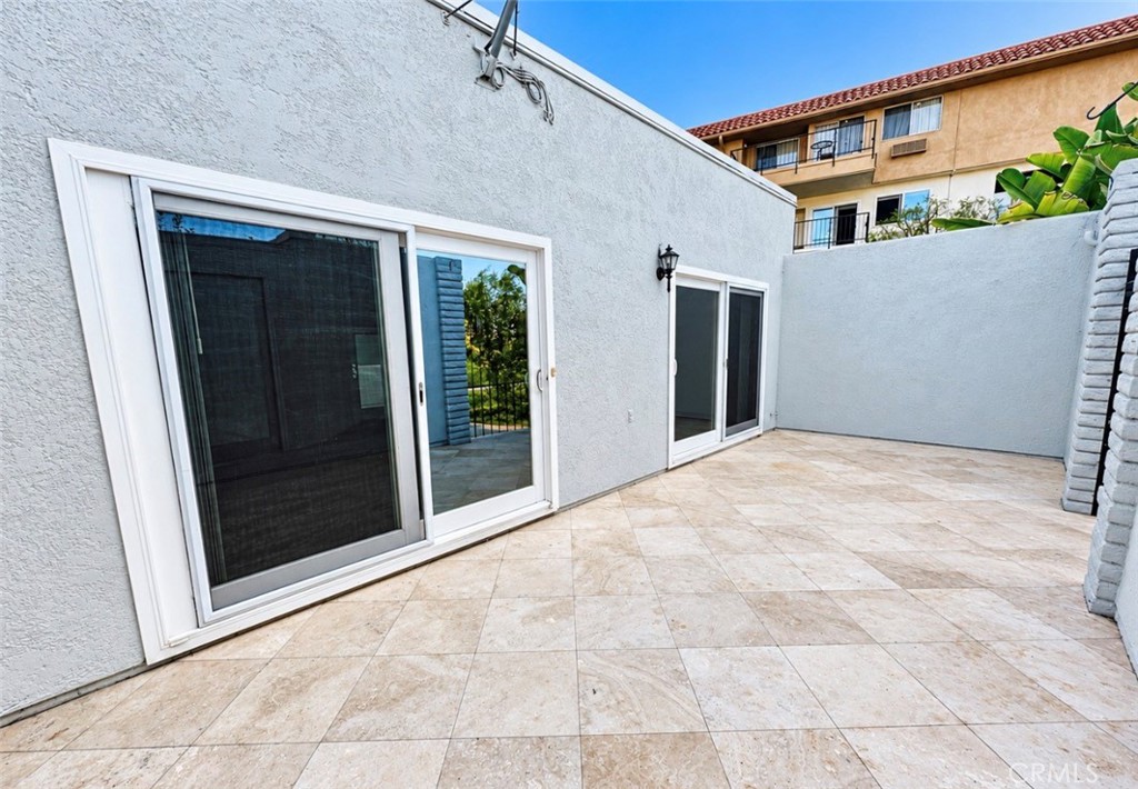 Step out from the living room onto the large gated back patio, with travertine tile flooring, a private outdoor retreat - 2346 Via Mariposa W A, Laguna Woods CA 92637 - photo 27