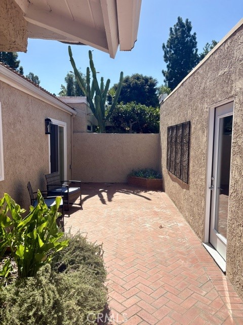 Side patio off the front courtyard. Door at right is the service door into the garage. Slider at back left opens to one - 3386 Punta Alta A, Laguna Woods CA 92637 - photo 4
